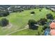 Scenic aerial view of the golf course with lush greenery, sand traps, and mature trees adding beauty to the community at 2232 Lake Vilma Dr, Orlando, FL 32835