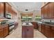 Spacious kitchen with stainless steel appliances, dark cabinets, an island, and tile flooring at 2232 Lake Vilma Dr, Orlando, FL 32835