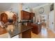 Open kitchen with granite countertops, dark cabinets, stainless appliances, and a view into the dining area at 2232 Lake Vilma Dr, Orlando, FL 32835