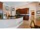 A spacious kitchen features dark wood cabinets, granite countertops, and travertine tile flooring, with island seating at 2232 Lake Vilma Dr, Orlando, FL 32835