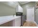 Bright laundry room features a utility sink, modern washer and dryer, and plenty of storage at 2232 Lake Vilma Dr, Orlando, FL 32835