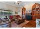 Living room featuring hardwood floors, comfortable leather seating, and custom built-in shelving units around a fireplace at 2232 Lake Vilma Dr, Orlando, FL 32835