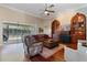This living room features hardwood floors, cozy leather seating, and custom built-in shelving units, with pool views at 2232 Lake Vilma Dr, Orlando, FL 32835