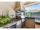 Well-equipped outdoor kitchen with stainless steel grill, sink, and counter space for seamless outdoor cooking at 2232 Lake Vilma Dr, Orlando, FL 32835