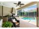 Covered patio with built-in grill area and views of sparkling pool and lush landscaping at 2232 Lake Vilma Dr, Orlando, FL 32835