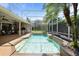 Beautiful screened-in pool with a spa, waterfall feature, and outdoor kitchen, perfect for relaxation at 2232 Lake Vilma Dr, Orlando, FL 32835
