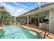 Lovely view of the sparkling swimming pool, outdoor kitchen, covered patio, and screened lanai at 2232 Lake Vilma Dr, Orlando, FL 32835