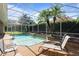 Inviting screened pool area with two tropical palms, a spa, and two chaise lounges for comfortable poolside lounging at 2232 Lake Vilma Dr, Orlando, FL 32835