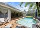 Beautiful screened-in pool with a spa, waterfall feature, and outdoor seating, perfect for relaxation at 2232 Lake Vilma Dr, Orlando, FL 32835
