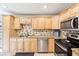 Modern kitchen with stainless steel appliances, granite counters, tile backsplash, and wooden cabinets at 2260 Winslow Cir, Casselberry, FL 32707