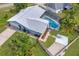 Aerial view of the home featuring a screened-in pool, long driveway, backyard landscaping, and a fenced in side yard at 2369 Haulover Blvd, Deltona, FL 32738