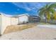 Fenced backyard with tropical landscaping, gravel, and a screened-in pool at 2369 Haulover Blvd, Deltona, FL 32738