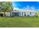 Charming single-story home with well-manicured lawn and garden beds, featuring blue shutters and a screened front porch at 2369 Haulover Blvd, Deltona, FL 32738