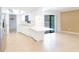 Bright kitchen featuring white countertops, cabinets, and a breakfast bar next to sliding glass doors to the pool area at 2369 Haulover Blvd, Deltona, FL 32738