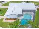 Aerial view of a screened-in pool and a well maintained lawn with tropical landscaping at the rear of the home at 2369 Haulover Blvd, Deltona, FL 32738