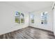 Bright bedroom with ample natural light from three windows and modern gray wood floors at 2378 Addalia Aly, Orlando, FL 32804