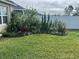 Lush backyard featuring a verdant lawn, landscaping, and a white vinyl fence for added privacy at 2711 Neverland Dr, New Smyrna Beach, FL 32168