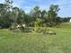 Beautiful backyard with green lawn and a garden area featuring various plants and small trees at 2711 Neverland Dr, New Smyrna Beach, FL 32168