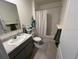 Well-lit bathroom featuring a single sink vanity, shower, and gray tile floors at 2711 Neverland Dr, New Smyrna Beach, FL 32168