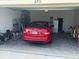 Well-organized garage with a red car, storage shelves, and various equipment at 2711 Neverland Dr, New Smyrna Beach, FL 32168