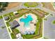 Aerial view showcasing a clover-shaped pool with a lounging area, cabanas, and adjacent parking at 2995 Flying Blackbird Rd, Bartow, FL 33830