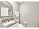 Stylish powder room with granite countertop, decorative mirror, and neutral color palette at 2995 Flying Blackbird Rd, Bartow, FL 33830