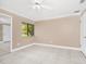 Bedroom with ceiling fan, tile floors, window and sliding mirrored closet doors at 3379 Monika Cir, Orlando, FL 32812