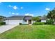 Charming single-story home with a well-manicured lawn and an inviting front entrance with a bright yellow door at 3379 Monika Cir, Orlando, FL 32812