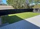 Large backyard with a freshly mowed lawn, enclosed by a black wooden fence and a gray deck at 37518 Quail Ridge Cir, Leesburg, FL 34788