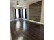 Bedroom with wood accent wall, dark wood flooring, and natural light from the windows at 37518 Quail Ridge Cir, Leesburg, FL 34788