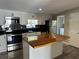 This kitchen features stainless steel appliances, custom cabinets, and a unique wood countertop island at 37518 Quail Ridge Cir, Leesburg, FL 34788