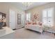 Charming bedroom with decorative daybed, chandelier, neutral walls, shutters, and decorative pillows at 3883 Grassland Loop, Lake Mary, FL 32746