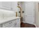 Close up of a bright butler's pantry with white cabinets, marble counters, and elegant decor at 3883 Grassland Loop, Lake Mary, FL 32746