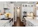 An open kitchen with white cabinetry, stainless steel appliances, and hardwood flooring, showcasing its seamless design at 3883 Grassland Loop, Lake Mary, FL 32746