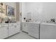 Well-lit laundry room features white cabinets, sleek countertops, and modern washer/dryer units at 3883 Grassland Loop, Lake Mary, FL 32746