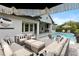 Stunning outdoor patio with luxurious pool and stylish seating with black and white accents at 3883 Grassland Loop, Lake Mary, FL 32746