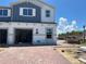 Newly constructed two-story townhome with a brick driveway, an attached garage, and blue and white siding at 4271 Campsite Loop, Orlando, FL 32824