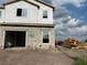 New construction home featuring an attached garage and large windows under a cloudy sky at 4271 Campsite Loop, Orlando, FL 32824