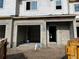 Construction progress showcases an unfinished townhome garage and doorway with block walls and Tyvek weatherproofing at 4287 Campsite Loop, Orlando, FL 32824