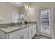 Bright bathroom features a double sink vanity, granite countertops, and access door to the pool at 4772 Kings Castle Cir, Kissimmee, FL 34746