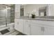Bathroom with a double sink granite vanity and walk-in shower at 4772 Kings Castle Cir, Kissimmee, FL 34746