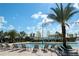Relaxing community pool featuring several lounge chairs and sun umbrellas, with many palm trees at 4772 Kings Castle Cir, Kissimmee, FL 34746