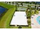 Aerial view of the sand volleyball court and basketball court, next to a lake and other community ammenities at 4772 Kings Castle Cir, Kissimmee, FL 34746