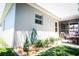 Exterior view of patio with green hose, lighting and a well-maintained garden at 4793 Grassy Knoll Dr, Tavares, FL 32778