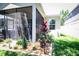 Landscaped backyard featuring decorative rocks, flower beds, and a screened-in lanai at 4793 Grassy Knoll Dr, Tavares, FL 32778