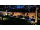 Beautiful backyard featuring manicured lawn, illuminated plants, and brick perimeter wall with uplighting at 4793 Grassy Knoll Dr, Tavares, FL 32778