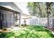 Lush backyard featuring a screened-in lanai, well-kept lawn, and privacy fence at 4793 Grassy Knoll Dr, Tavares, FL 32778