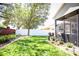 Spacious backyard with lush grass, a screened-in lanai, and well-maintained landscaping at 4793 Grassy Knoll Dr, Tavares, FL 32778