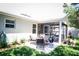 Backyard with a screened-in porch, a patio set, and well-maintained landscaping at 4793 Grassy Knoll Dr, Tavares, FL 32778
