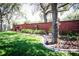 Well-manicured backyard with a brick wall, garden beds, and mature trees at 4793 Grassy Knoll Dr, Tavares, FL 32778